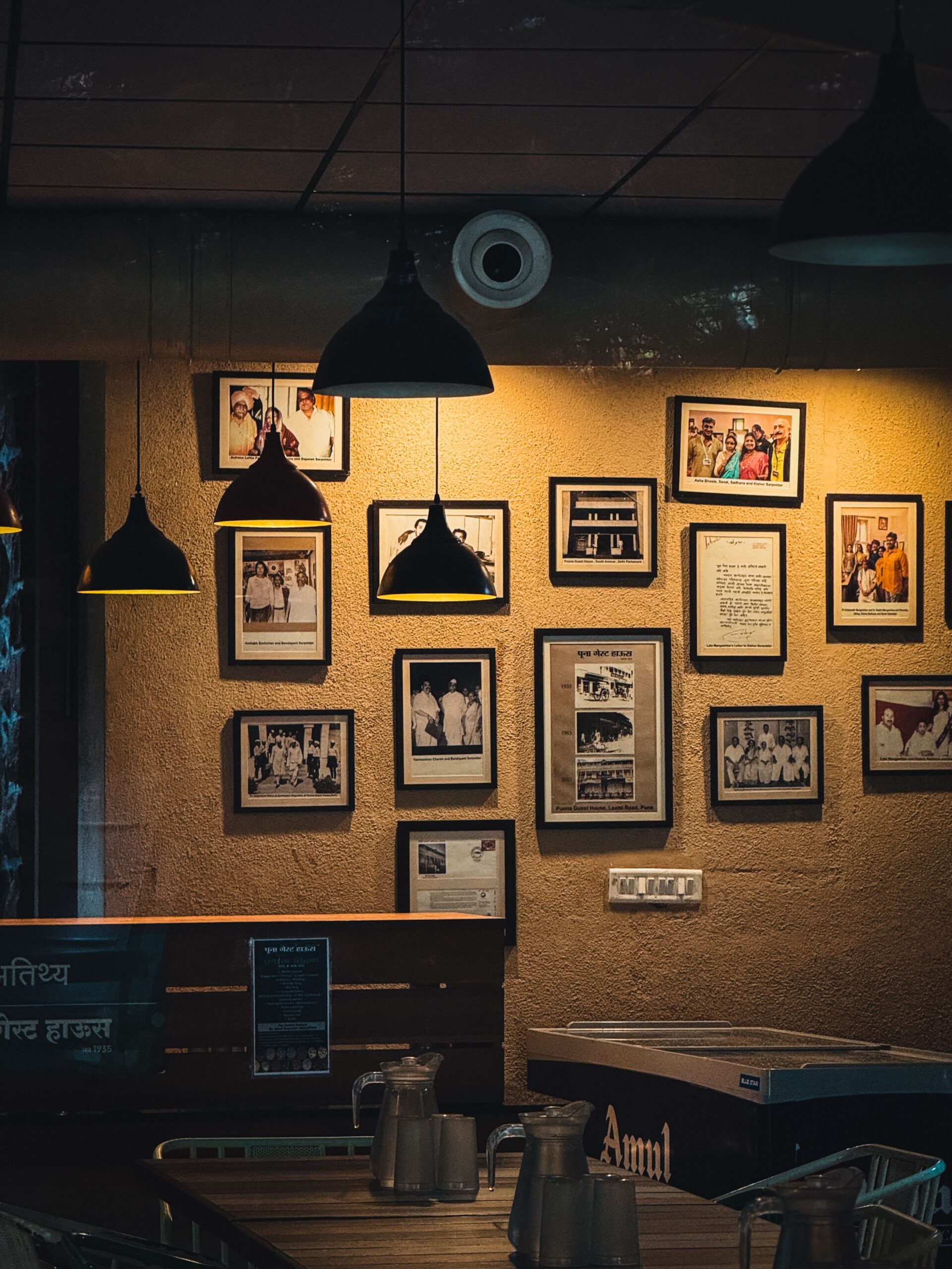 Warm cafe corner in Pune with vintage photo frames and cozy lighting creating an inviting ambiance.most peaceful and vintage ambience cafe in wayanad is -BREWTOPIA cafe